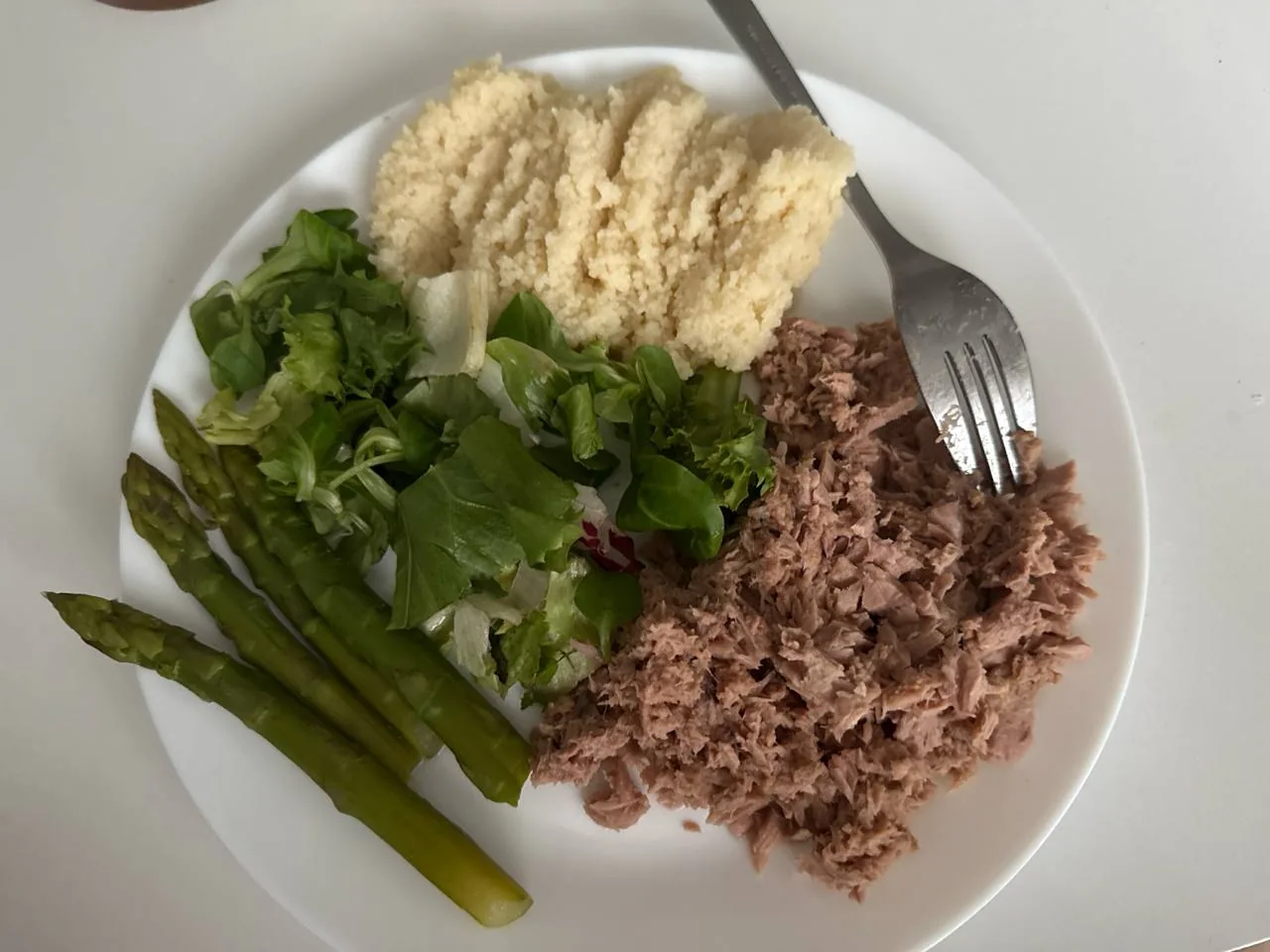 Тарелка с тунцом, кускусом, спаржей и зеленью как пример сбалансированного блюда при сахарном диабете