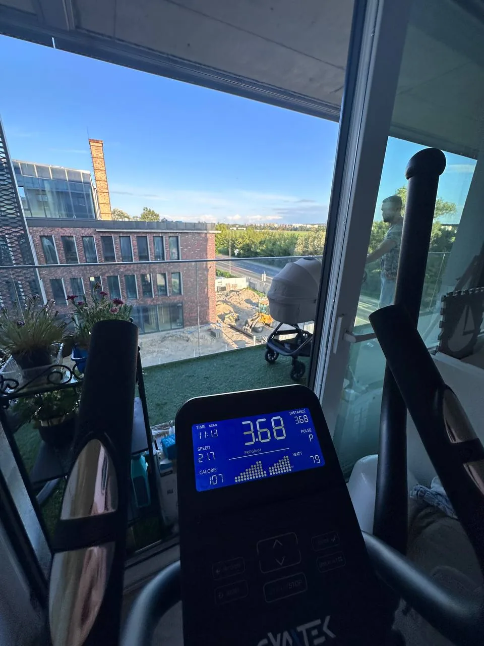 Кардиотренажёр в зале с видом на балкон и человека за окном, символизирующий путь к более устойчивому снижению веса